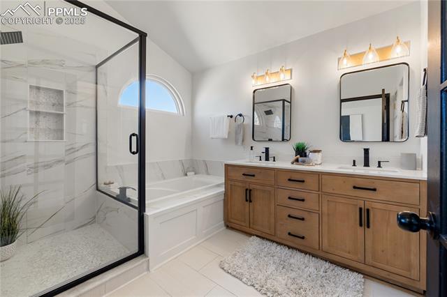 7827 Swiftrun Road Colorado Springs, CO 80920 - Photo 19 of 48 Full bath with double vanity, a sink, a marble finish shower, and a bath