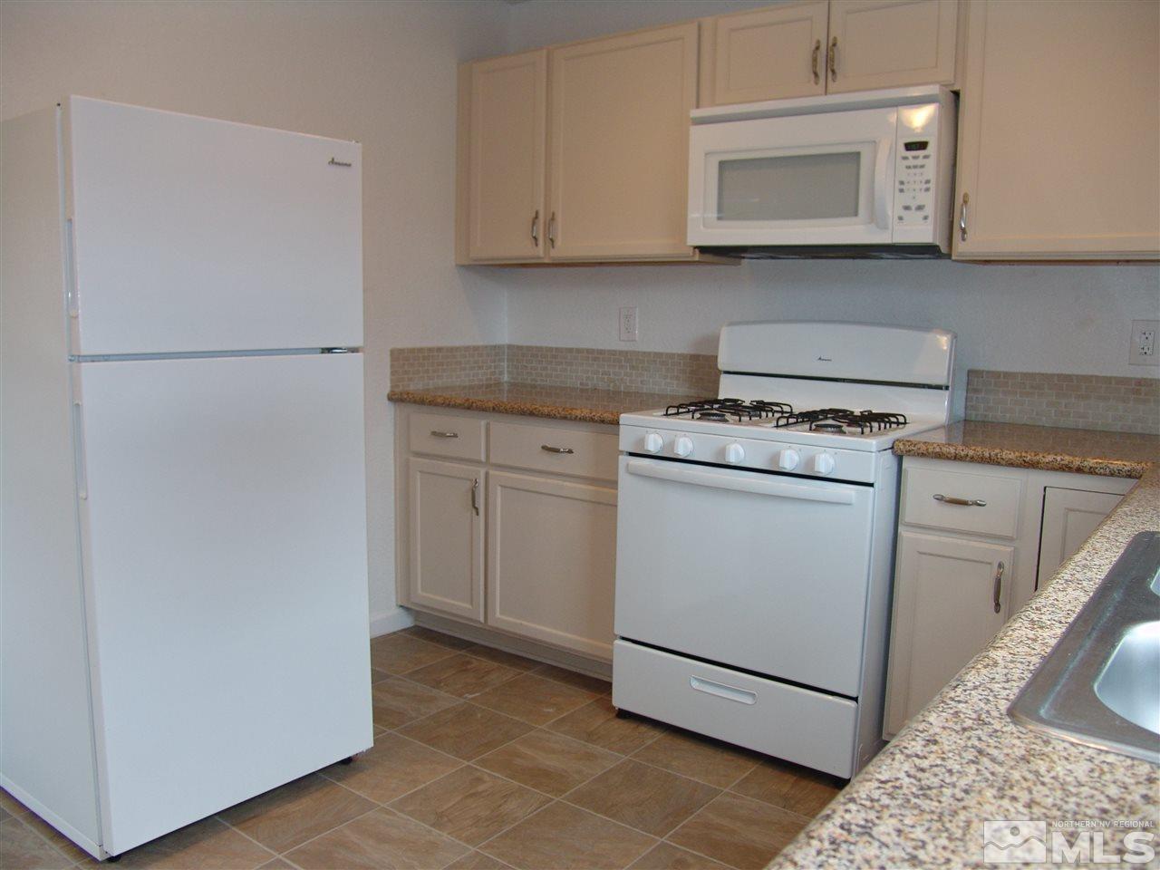 795 Montello Street Reno, NV 89512 - Photo 5 of 13 a kitchen with a stove a sink and a refrigerator