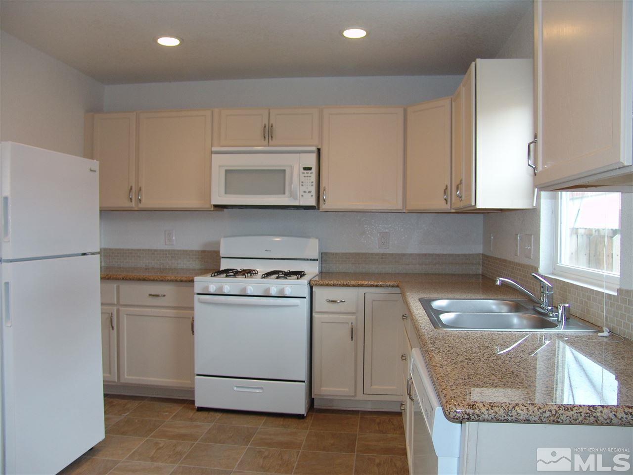 795 Montello Street Reno, NV 89512 - Photo 7 of 13 a kitchen with granite countertop white cabinets and a sink
