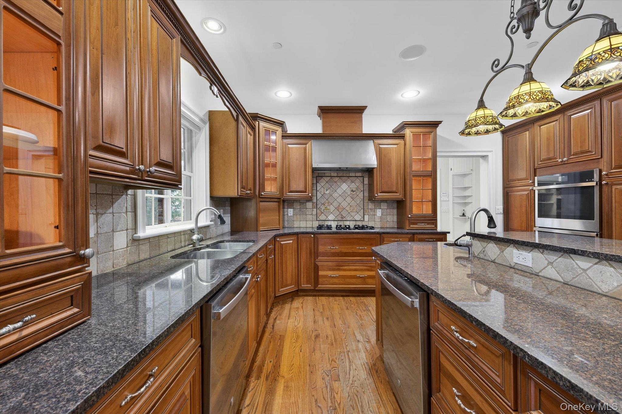 7 Farm Hollow Road New Windsor, NY 12553 - Photo 12 of 36 Kitchen featuring light wood-type flooring, wood finish cabinetry, dark stone countertops, glass fronted cabinets, and decorative light fixtures