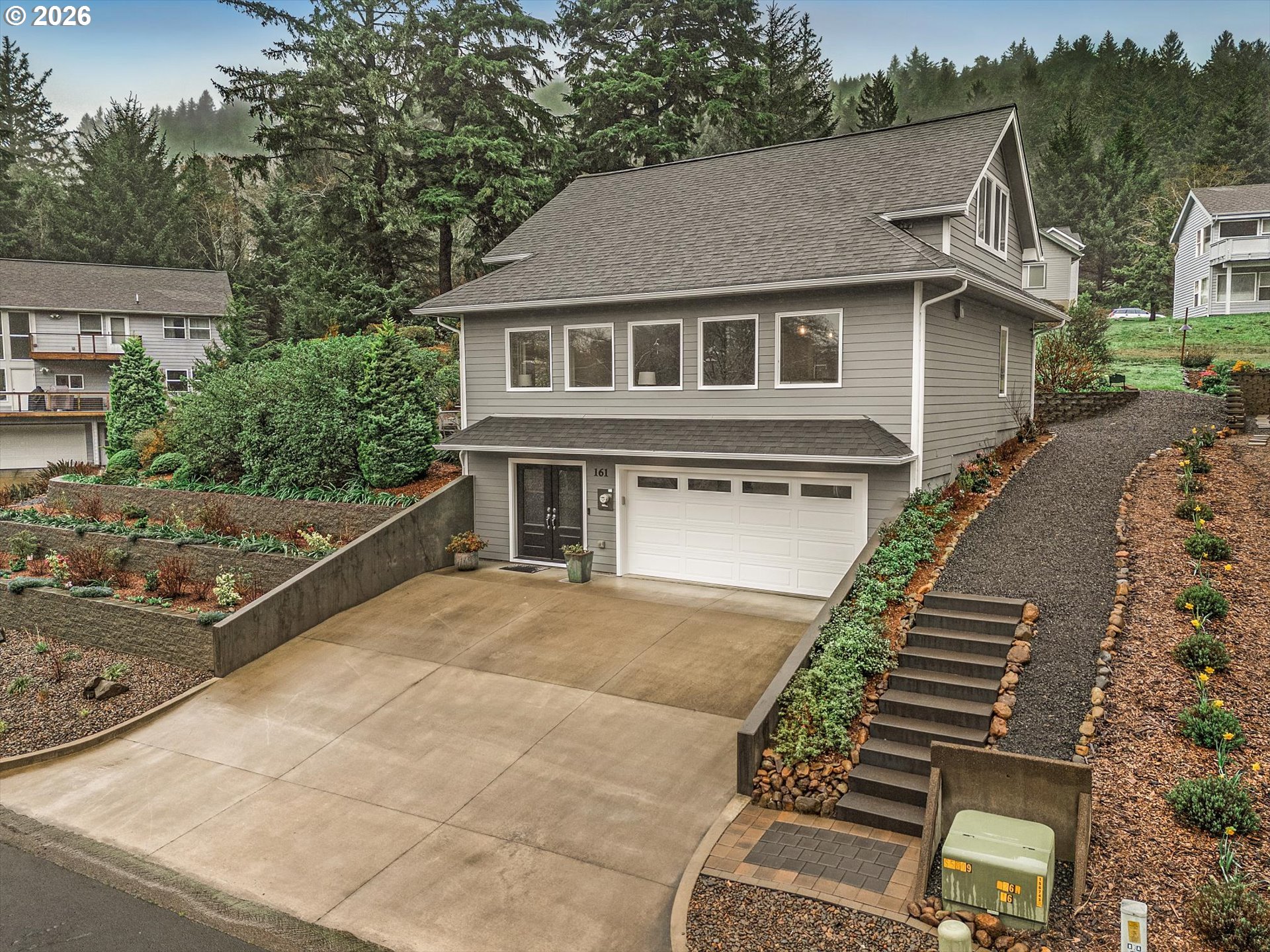 161 Combs Circle Yachats, OR 97498 - Photo 12 of 48 a front view of a house with a yard and garage