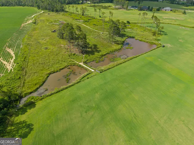 a view of a big house with a big yard and large trees