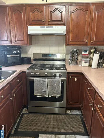 a kitchen with stainless steel appliances granite countertop a sink a stove and cabinets