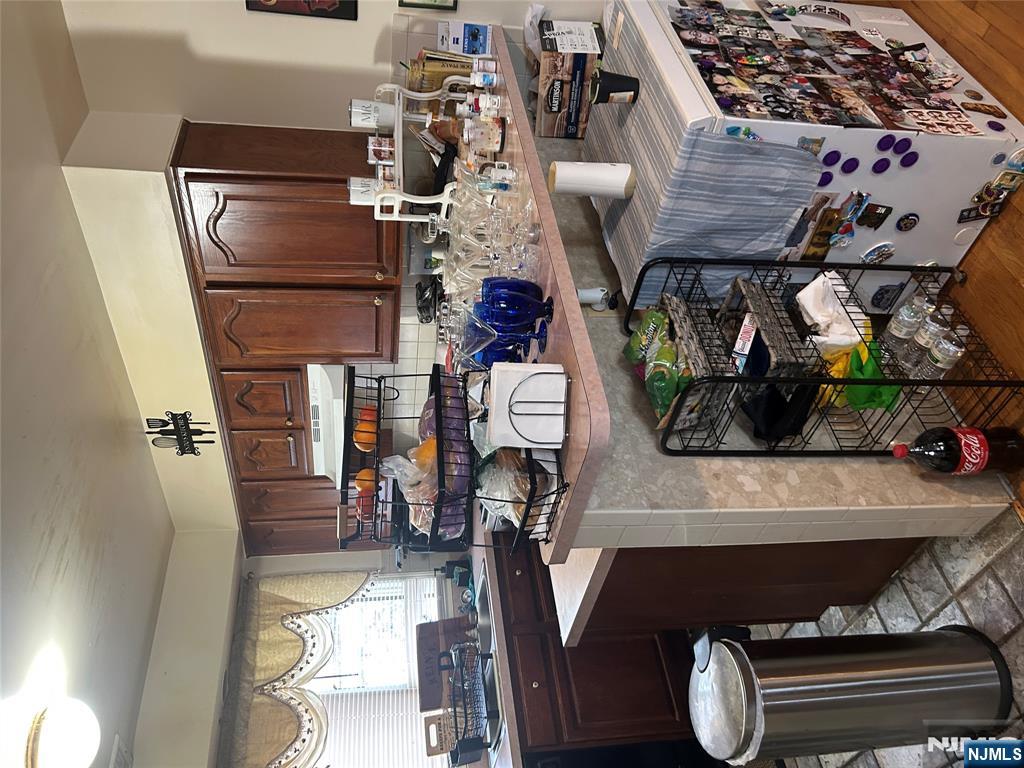 382 Lakeview Avenue, Unit 1 Clifton, NJ 07011 - Photo 13 of 13 a kitchen with stainless steel appliances kitchen island granite countertop a table chairs in it and a window