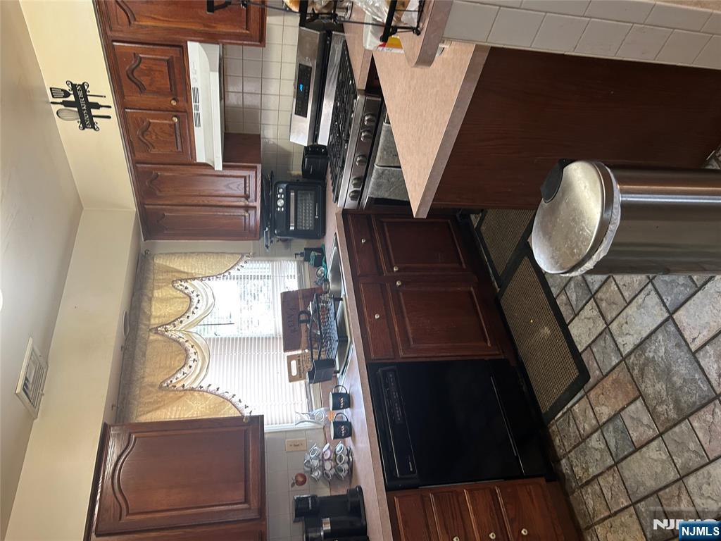 382 Lakeview Avenue, Unit 1 Clifton, NJ 07011 - Photo 10 of 13 a kitchen with a sink a stove a microwave and cabinetry