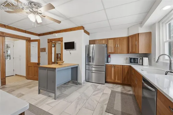 a kitchen with a refrigerator sink and cabinets