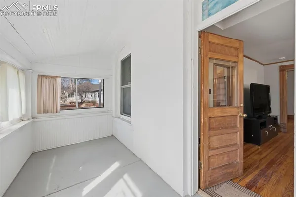 a view of a hallway with wooden floor and closet