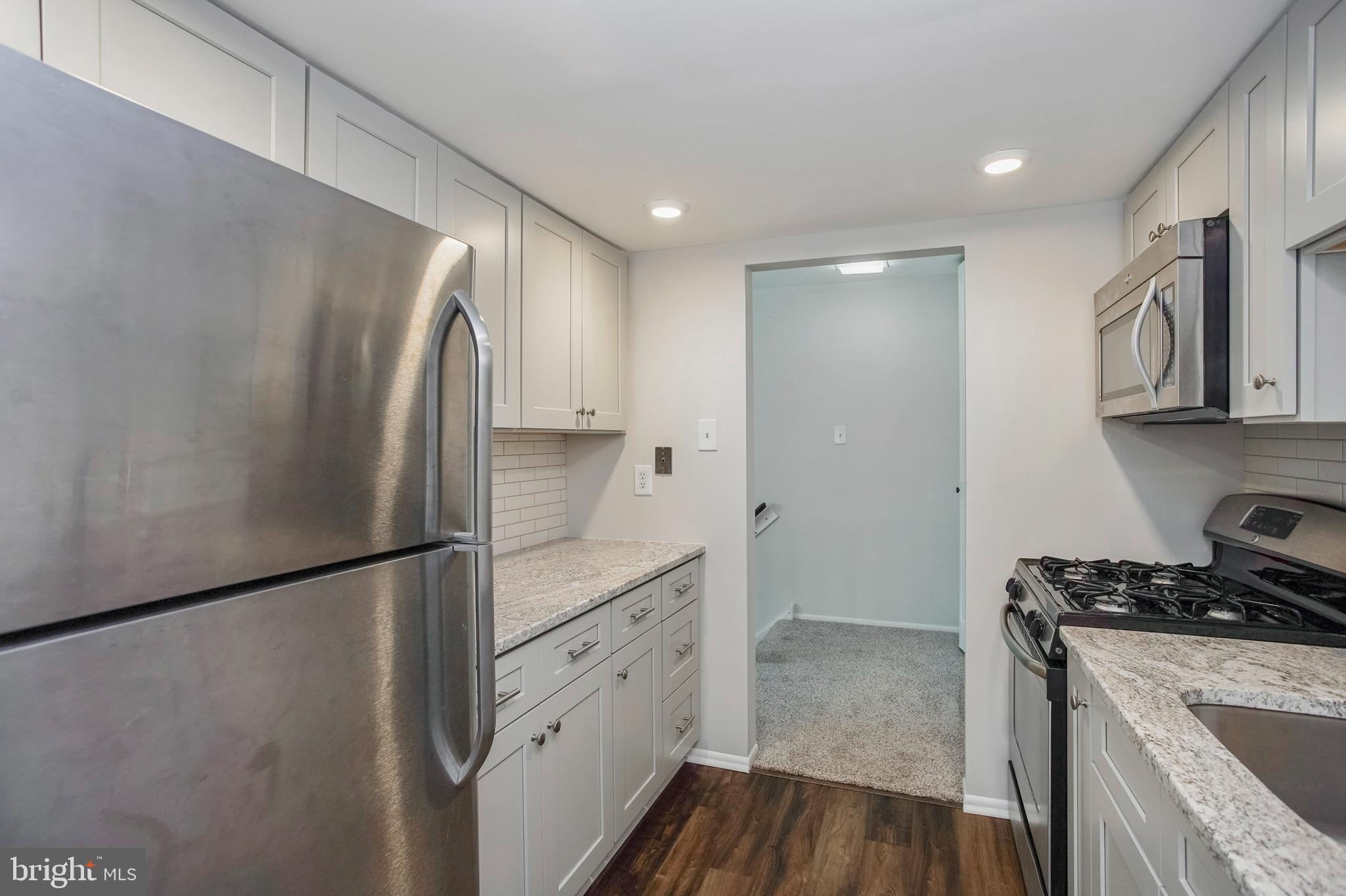 58 Old Forge Crossing Devon, PA 19333 - Photo 17 of 23 a kitchen with stainless steel appliances granite countertop a refrigerator a stove and a sink with wooden floor