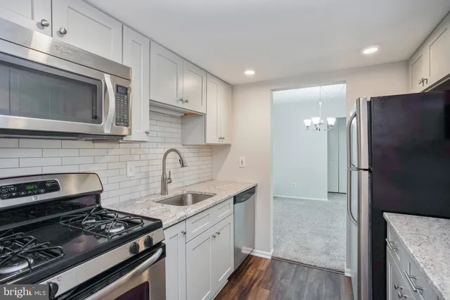 a kitchen with stainless steel appliances granite countertop a stove a refrigerator and a microwave