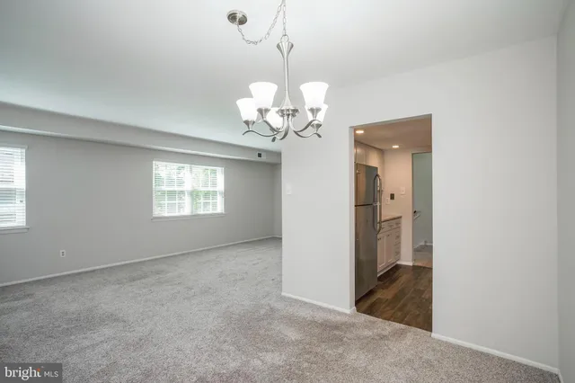 a view of a room with a chandelier fan and windows