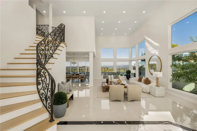 a room with lots of white furniture and wooden floor