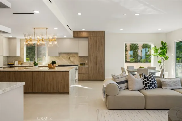 a large white kitchen with a sink and dishwasher a stove top oven with wooden floor