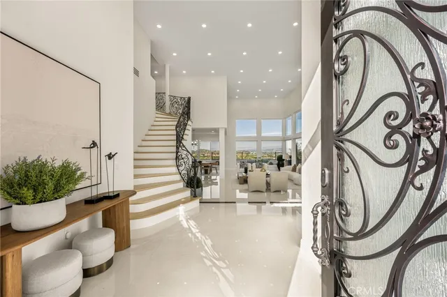 a living room with furniture a large window and a chandelier