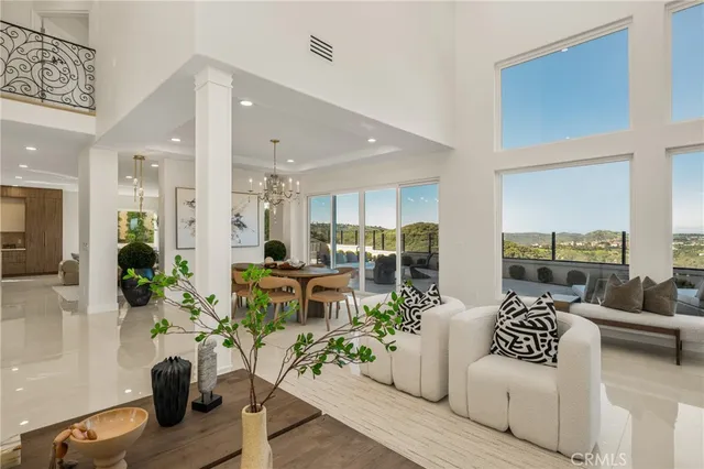 a living room with furniture potted plant and open kitchen view