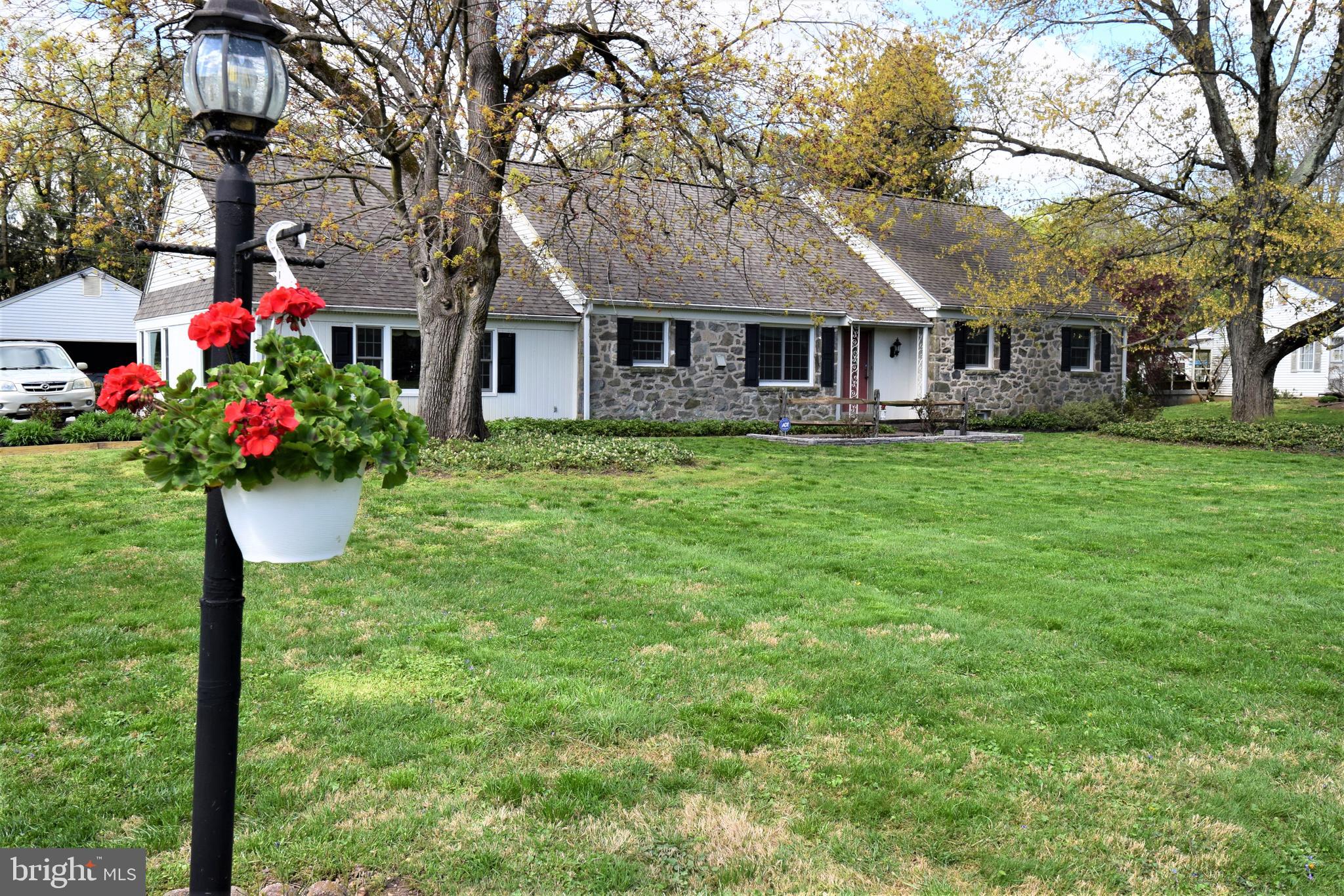 1550 Glenhardie Road Wayne, PA 19087 - Photo 1 of 38 a front view of a house with a garden and trees