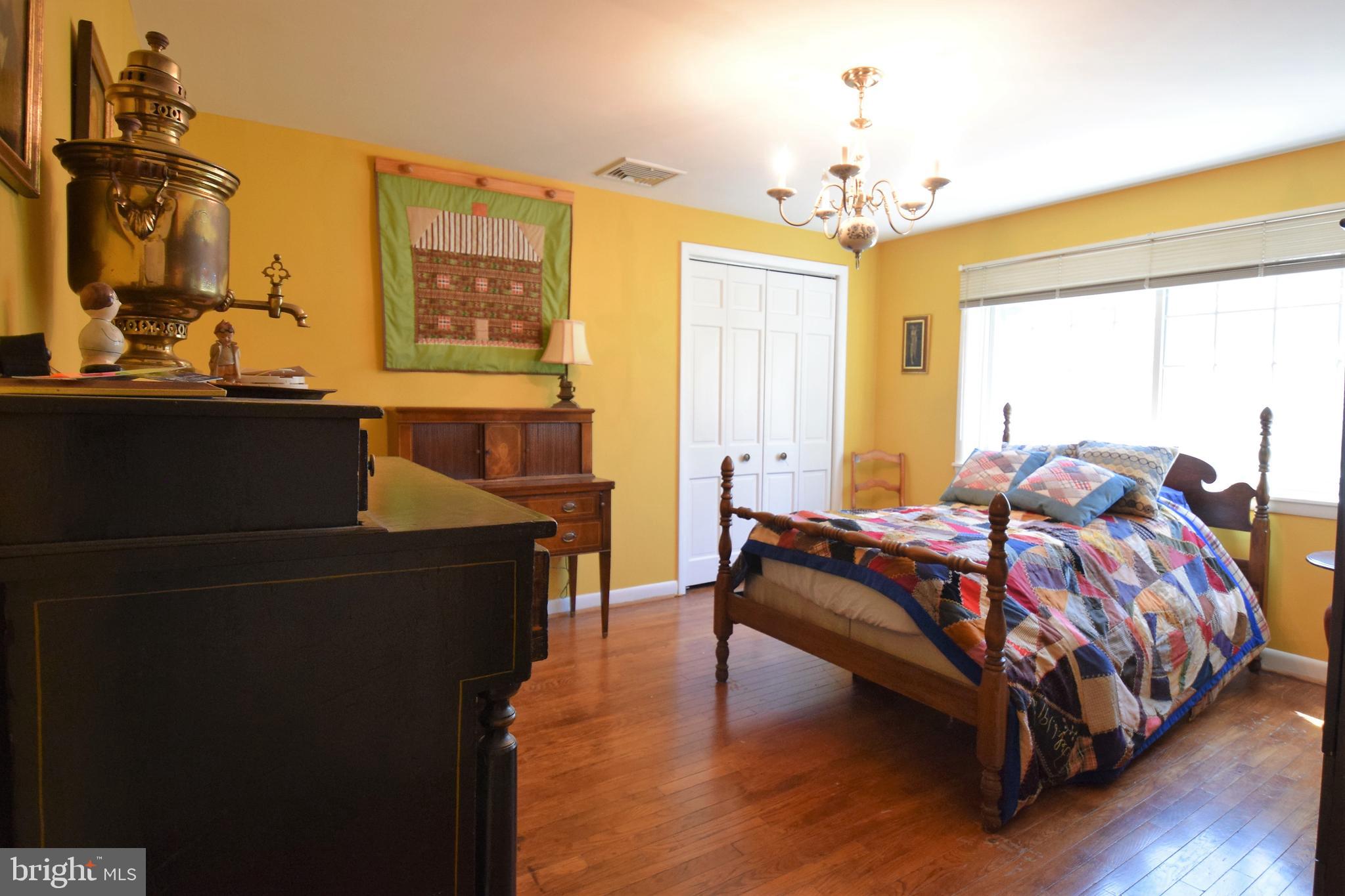 1550 Glenhardie Road Wayne, PA 19087 - Photo 20 of 38 a spacious bedroom with a bed and a chandelier