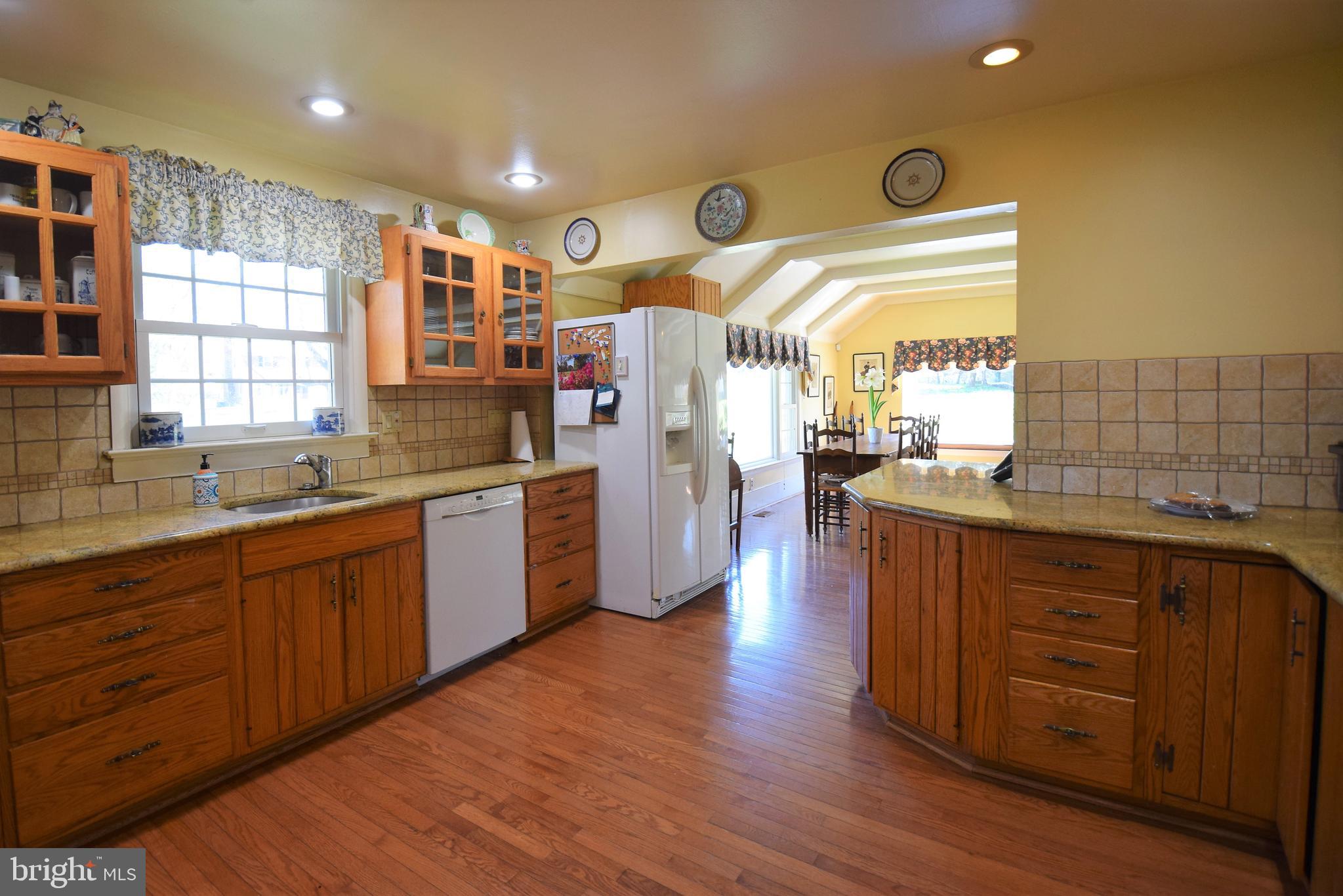 1550 Glenhardie Road Wayne, PA 19087 - Photo 7 of 38 a large kitchen with stainless steel appliances wooden floor and wooden cabinets