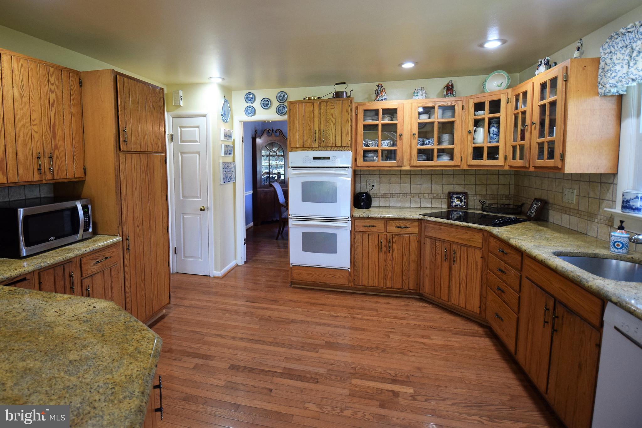 1550 Glenhardie Road Wayne, PA 19087 - Photo 8 of 38 a kitchen with stainless steel appliances granite countertop wooden cabinets a sink a stove a refrigerator and dishwasher with wooden floor