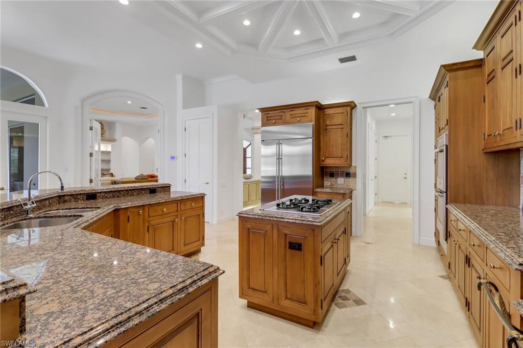 9376 Sweetgrass Way Naples, FL 34108 - Photo 14 of 49 a kitchen with kitchen island granite countertop a stove and a sink
