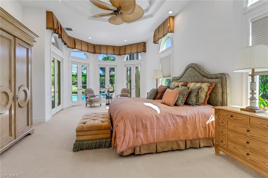 9376 Sweetgrass Way Naples, FL 34108 - Photo 19 of 49 a spacious bedroom with a bed and a chandelier