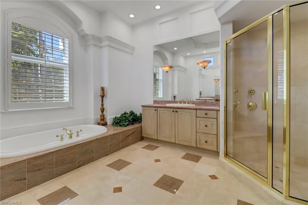 9376 Sweetgrass Way Naples, FL 34108 - Photo 23 of 49 a large bathroom with a tub sink shower and mirror
