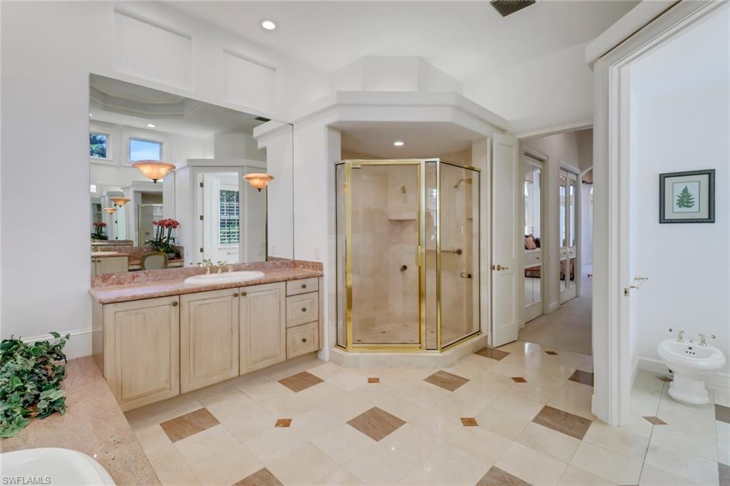 9376 Sweetgrass Way Naples, FL 34108 - Photo 25 of 49 a bathroom with a granite countertop sink mirror and shower