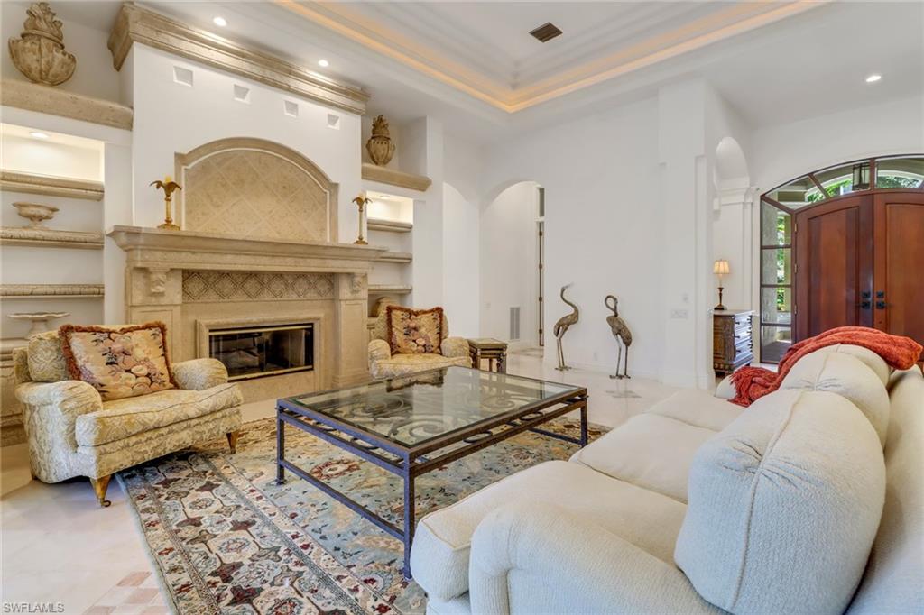 9376 Sweetgrass Way Naples, FL 34108 - Photo 3 of 49 a living room with furniture and a fireplace