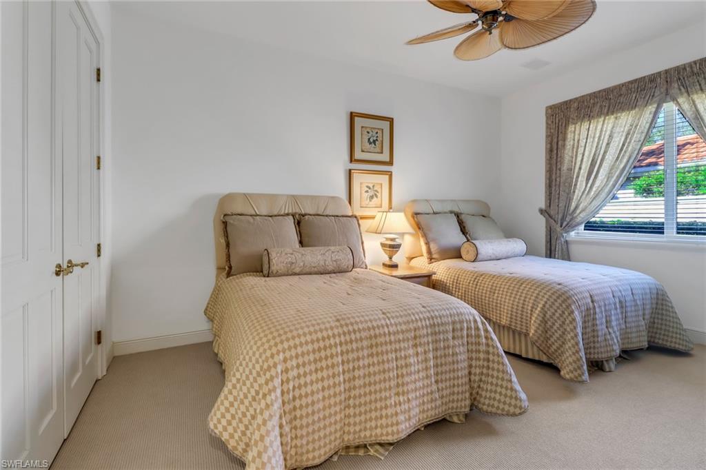 9376 Sweetgrass Way Naples, FL 34108 - Photo 31 of 49 a bedroom with two beds and a chandelier