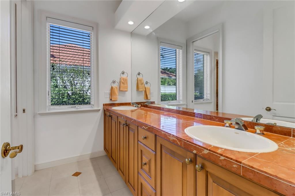 9376 Sweetgrass Way Naples, FL 34108 - Photo 33 of 49 a bathroom with a granite countertop sink and a large mirror