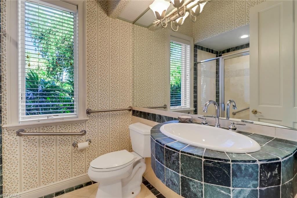 9376 Sweetgrass Way Naples, FL 34108 - Photo 39 of 49 a bathroom with a sink a toilet a mirror and a window