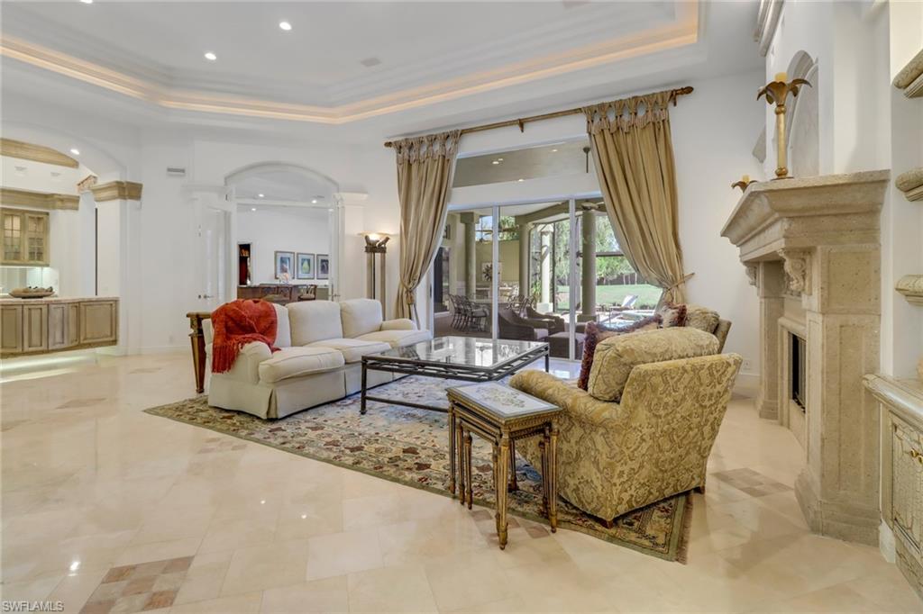 9376 Sweetgrass Way Naples, FL 34108 - Photo 4 of 49 a living room with furniture and a fireplace