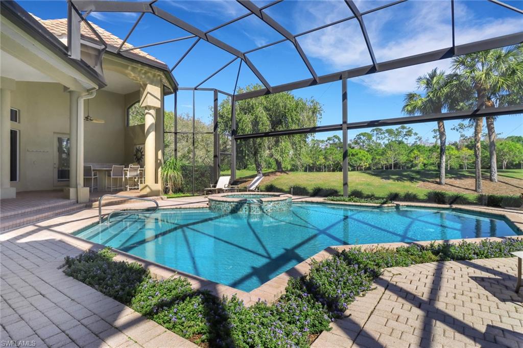 9376 Sweetgrass Way Naples, FL 34108 - Photo 46 of 49 a view of a patio with a table and chairs under an umbrella