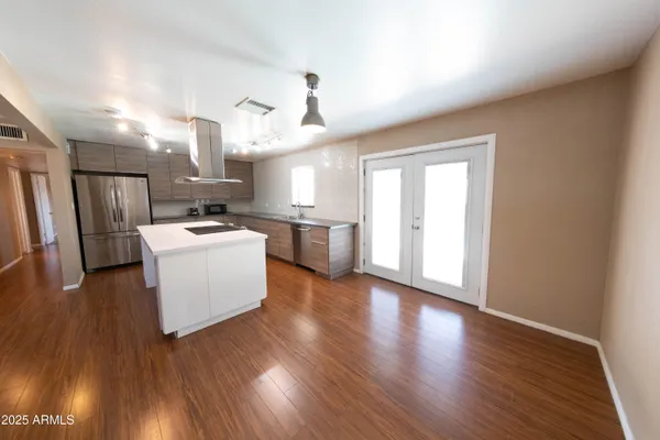 a kitchen with stainless steel appliances a white stove top oven a sink dishwasher and a refrigerator with wooden floor