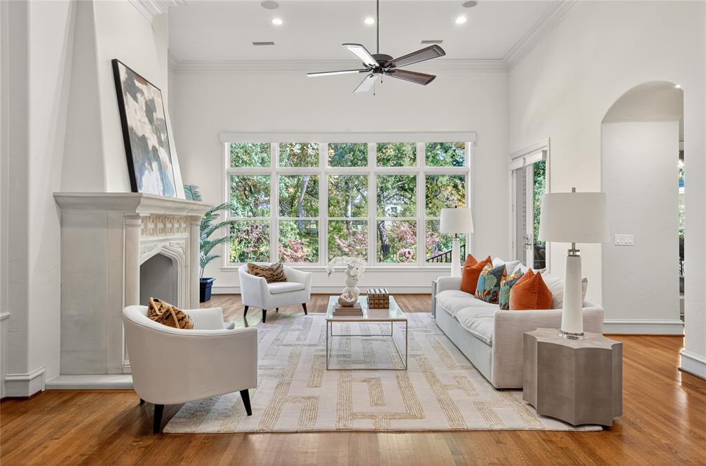 11836 Preston Brook Place Dallas, TX 75230 - Photo 11 of 40 Living area featuring healthy amount of natural light, a premium fireplace, wood finished floors, ceiling fan, and crown molding