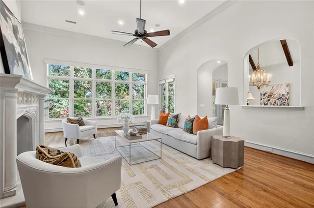 a living room with fireplace furniture and a large window