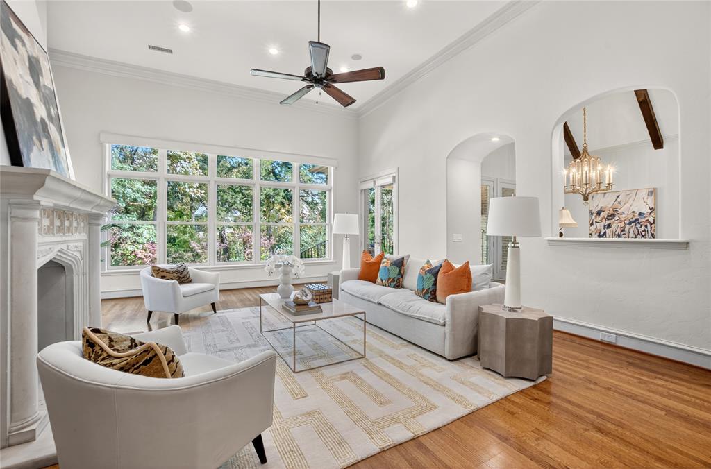 11836 Preston Brook Place Dallas, TX 75230 - Photo 12 of 40 Living room with wood finished floors, healthy amount of natural light, a high end fireplace, a chandelier, and ornamental molding