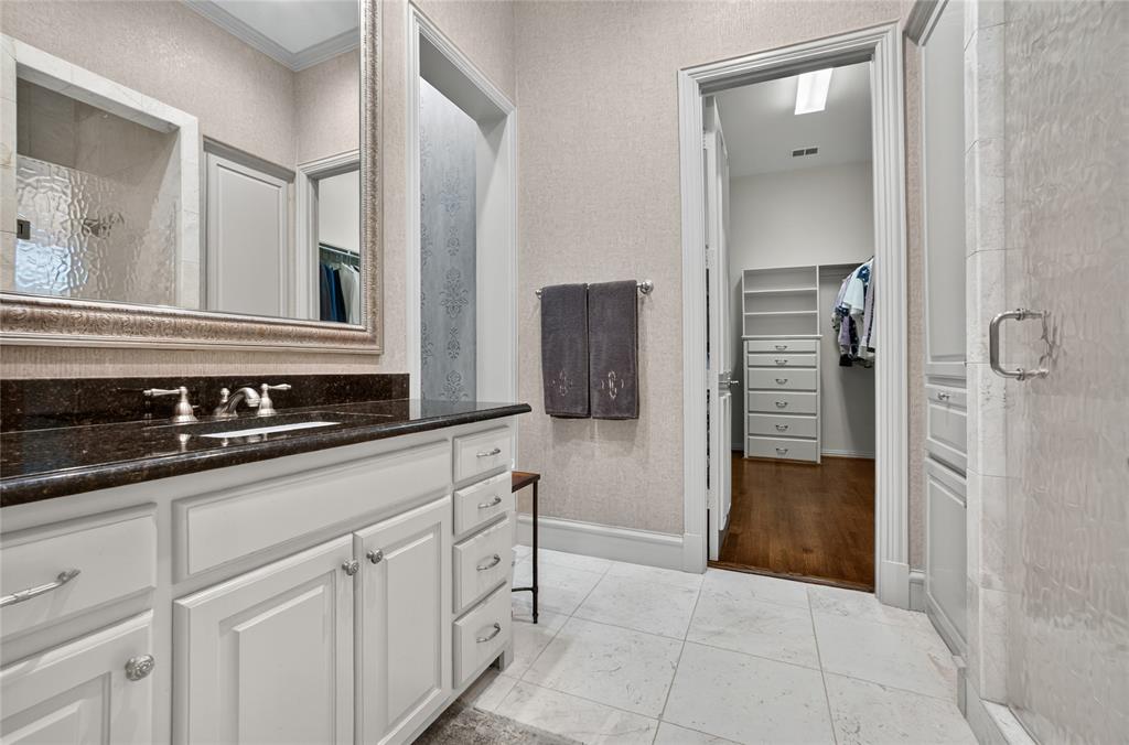 11836 Preston Brook Place Dallas, TX 75230 - Photo 22 of 40 Bathroom featuring a spacious closet, vanity, a shower with shower door, light tile patterned floors, and ornamental molding