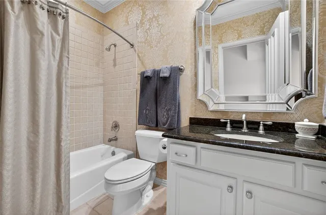 a bathroom with a granite countertop sink a toilet and a mirror