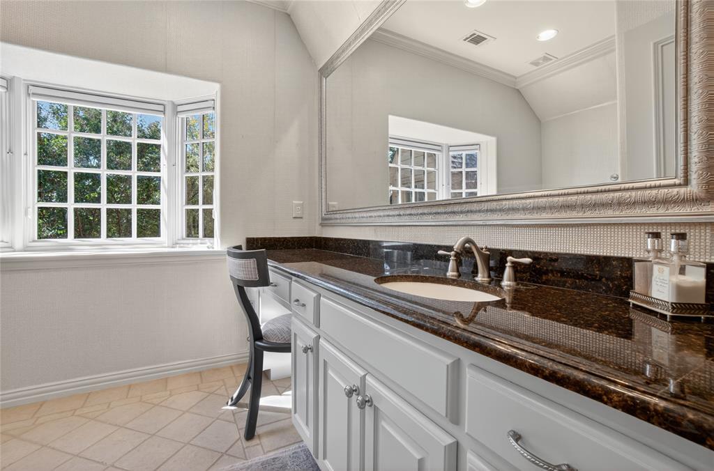 11836 Preston Brook Place Dallas, TX 75230 - Photo 26 of 40 Bathroom featuring vanity, healthy amount of natural light, ornamental molding, light tile patterned floors, and backsplash