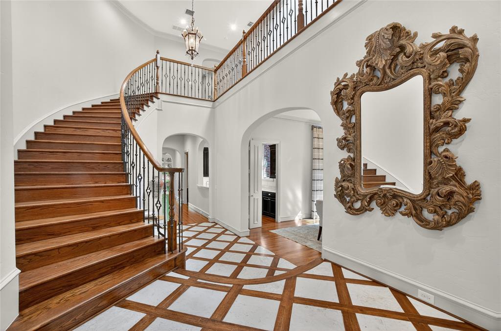 11836 Preston Brook Place Dallas, TX 75230 - Photo 3 of 40 Entryway with stairs, inlaid floor details, a towering ceiling, arched walkways, and crown molding