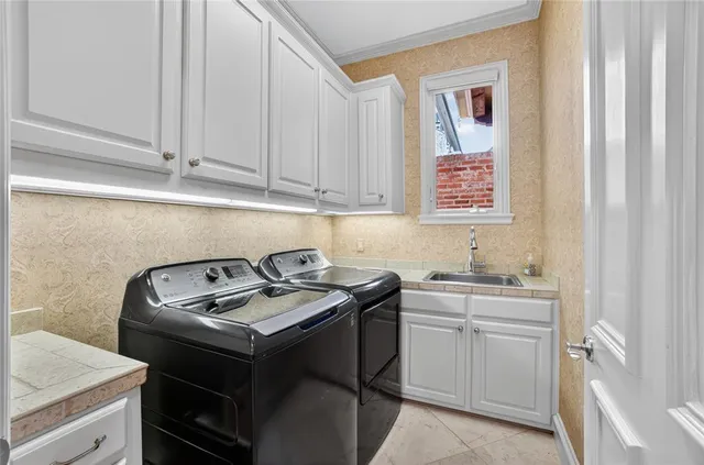 a utility room with sink dryer and washer