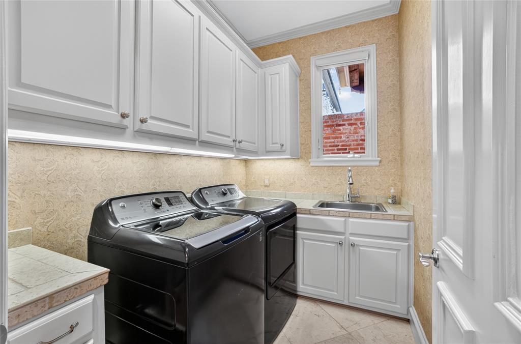 11836 Preston Brook Place Dallas, TX 75230 - Photo 31 of 40 Laundry area featuring wallpapered walls, washing machine and dryer, cabinet space, and ornamental molding