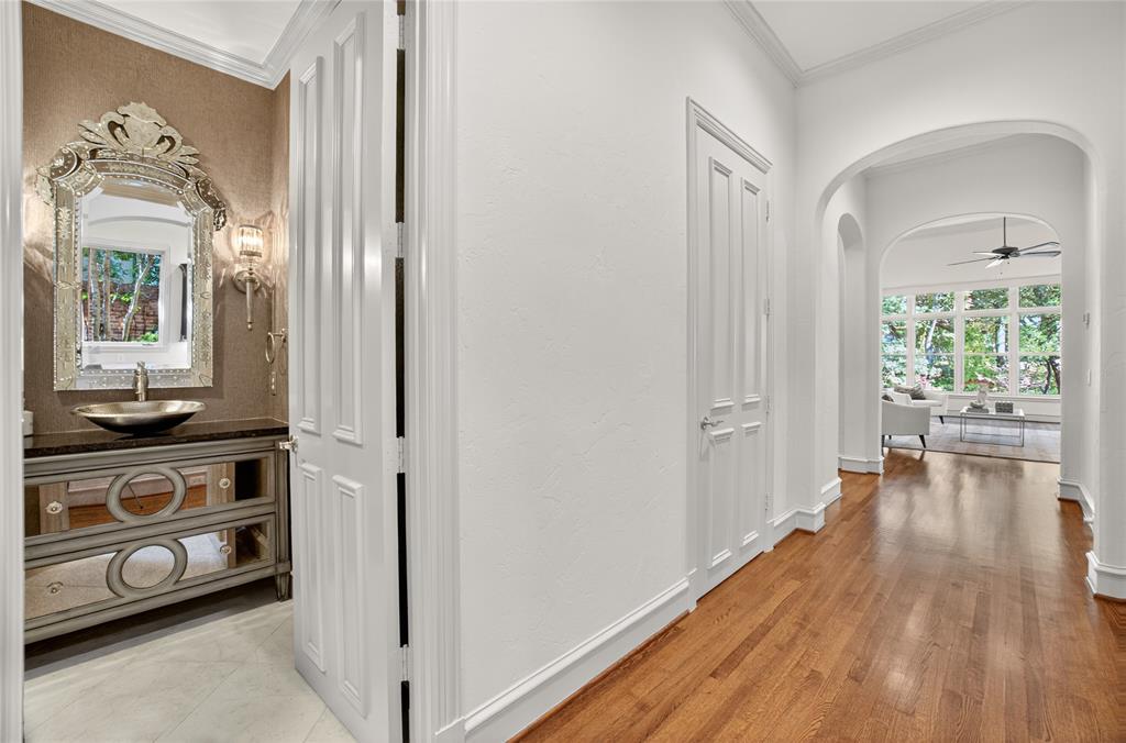 11836 Preston Brook Place Dallas, TX 75230 - Photo 9 of 40 Hall featuring arched walkways, crown molding, and light wood-style flooring