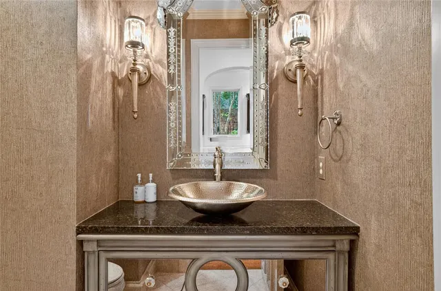 a bathroom with a granite countertop sink a mirror and shower