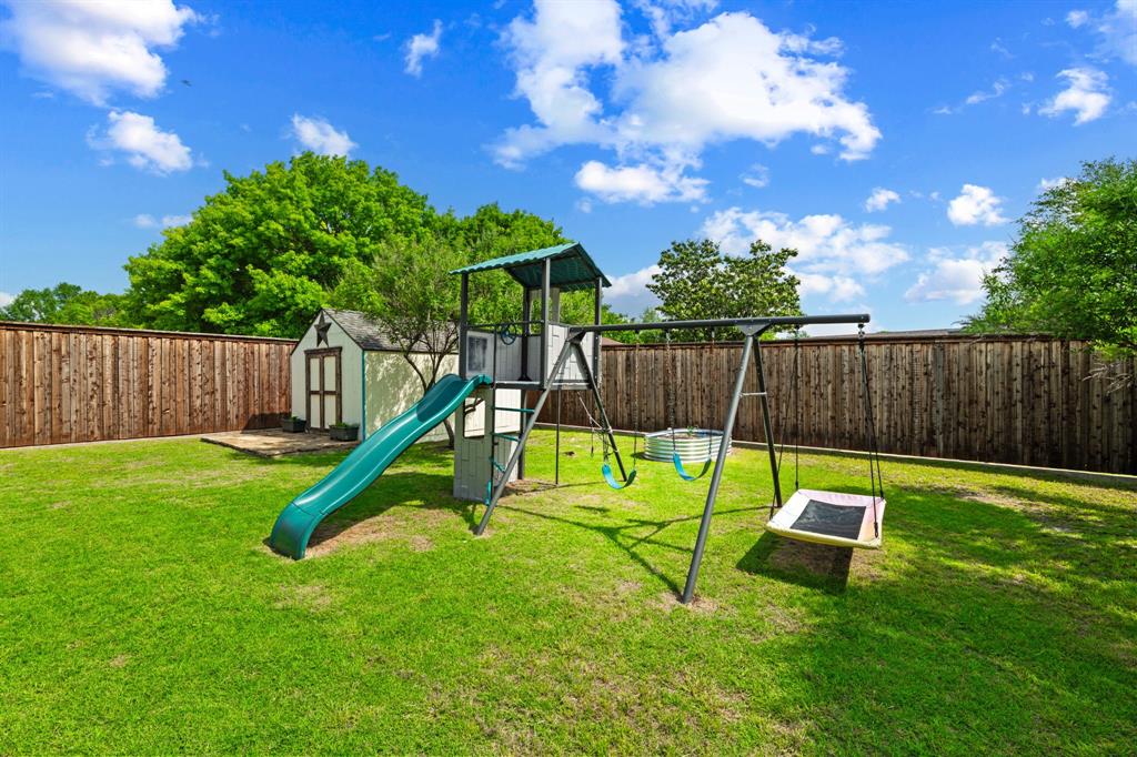224 Overcrest Drive Benbrook, TX 76126 - Photo 33 of 39 a view of a backyard with a slide trees and wooden fence