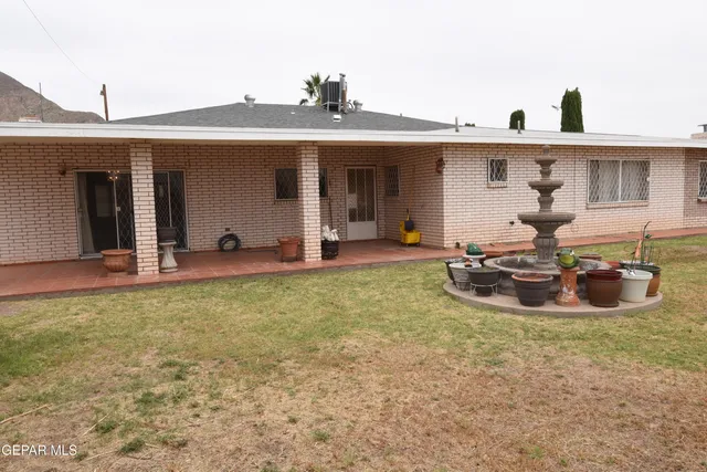 a view of a house with backyard and sitting area