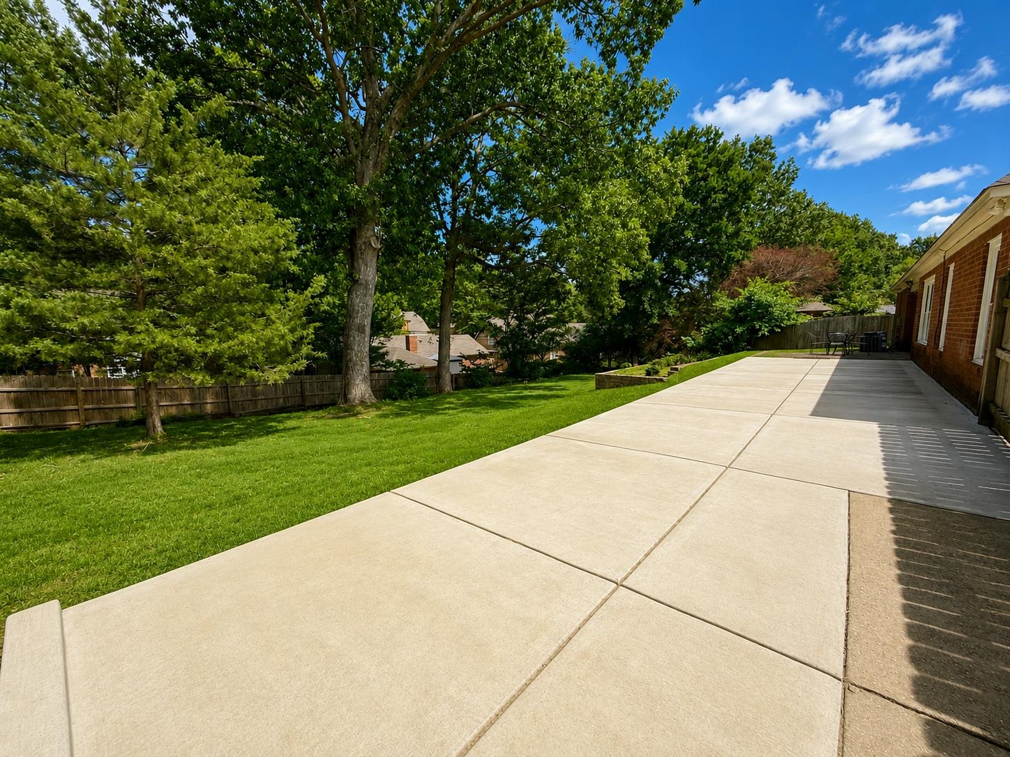326 South Sanga Road Cordova, TN 38018 - Photo 30 of 32 Expansive concrete patio with a manicured lawn, mature trees, and a privacy fence