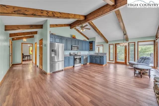 a view of a livingroom with wooden floor and furniture
