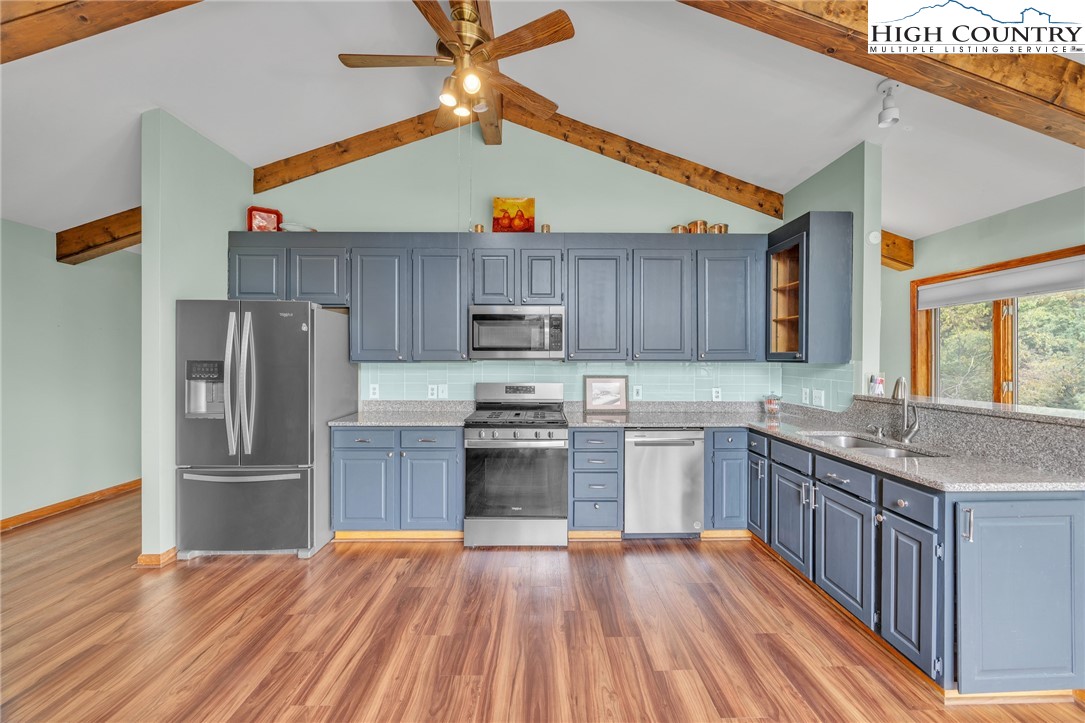 255 Clear View Ridge Crumpler, NC 28617 - Photo 6 of 33 a kitchen with granite countertop wooden floors and stainless steel appliances