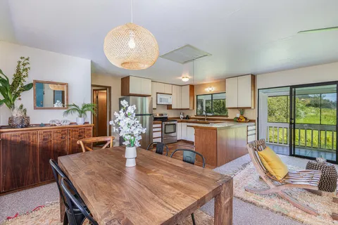 a view of a dining room with furniture a kitchen and chandelier